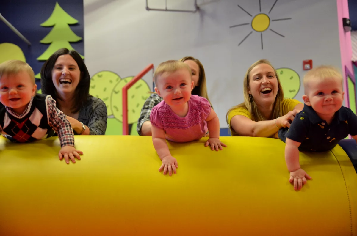 download-7 Parents at Romp n' Roll playing with kids on gym equipment.