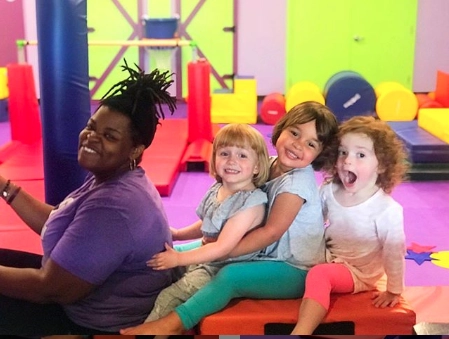 download-1 A little girl playing on Romp n' Roll's gym equipment while her parents enjoy a morning out.